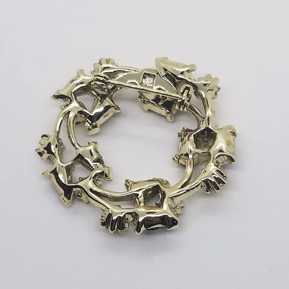 gold tone wreath brooch with clear green and black accents